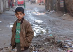 An Iraqi boy comes out of his home to meet U.S. soldiers conducting a cordon and search operation in Sadr City