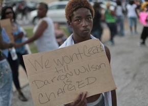 A protester in Ferguson calls for Mike Brown's murderer to be arrested